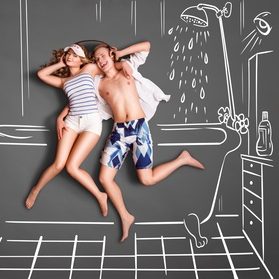 Junge und Mädchen liegen entspannt in einer Badewanne mit künstlerischem Hintergrund.